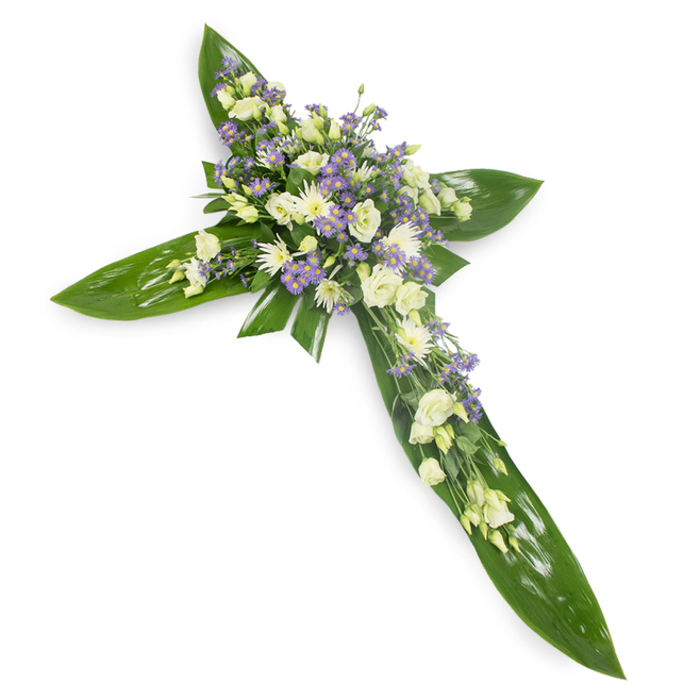 This photographic study of a sympathy cross is composed with an eye for quiet dignity and tactile contrast, set against a plain white background and shot slightly from above so shape and texture are immediately legible. A foundation of large, glossy green tropical leaves - carefully layered to suggest sheltering wings - forms the precise cross silhouette; their waxy surfaces and visible veins provide a bold, grounding green that anchors the design. At the nexus and extending along each arm, creamy-white lisianthus bloom in soft, ruffled clusters, their layered petals and occasional closed buds evoking gentleness and restraint. Intermingled with them are small, rounded white chrysanthemums or similar spray blooms that throw tiny highlights across the mass. Delicate sprays of lavender-hued star-like flowers, likely limonium or small asters, thread through the composition to introduce cool color notes and a sense of depth. Slender green filler foliage peeks through the florals, softening transitions and adding an organic whisper. The lighting is even and serene, bathing the arrangement in a calm radiance that enhances the pale palette and underscores its purpose: a memorial tribute for services, graveside remembrances, or church ceremonies. For those arranging flowers near Beckton DLR or the Royal Docks, this cross communicates solace and faith - a handcrafted floral emblem of remembrance and quiet hope.